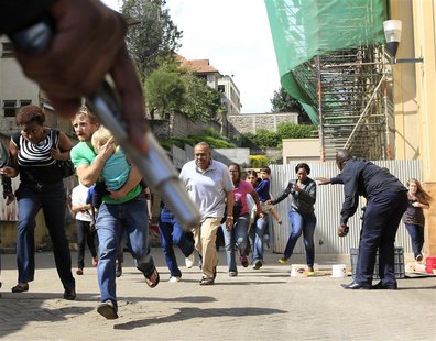 A police officer holds a gun to provide cover for customers running out as a shooting took place at Westgate shopping mall in Nairobi Septem A police officer holds a gun to provide cover for customers running out as a shooting took place at Westgate shopping mall in Nairobi Septem