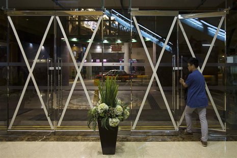 A man leaves a shopping mall, which entrances are taped in anticipation of Typhoon Usagi, in Hong Kong September 21, 2013. REUTERS/Tyrone Si A man leaves a shopping mall, which entrances are taped in anticipation of Typhoon Usagi, in Hong Kong September 21, 2013. REUTERS/Tyrone Si