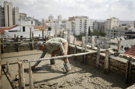 A Palestinian worker flattens cement on the roof of a building under construction in Gaza City September 22, 2013. REUTERS/Mohammed Salem A Palestinian worker flattens cement on the roof of a building under construction in Gaza City September 22, 2013. REUTERS/Mohammed Salem