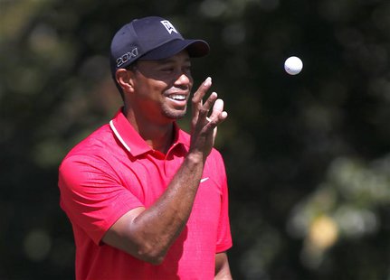 Tiger Woods of the U.S. catches a ball before his putt from his caddie on the second hole in the final round of the Tour Championship golf t Tiger Woods of the U.S. catches a ball before his putt from his caddie on the second hole in the final round of the Tour Championship golf t