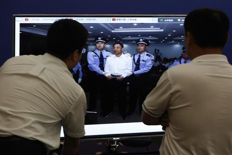 Men look at a screen displaying a picture of disgraced Chinese politician Bo Xilai standing trial on the website of a court's microblog, in Men look at a screen displaying a picture of disgraced Chinese politician Bo Xilai standing trial on the website of a court's microblog, in