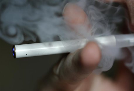 A man uses an E-cigarette, an electronic substitute in the form of a rod, slightly longer than a normal cigarette, in this illustration pict A man uses an E-cigarette, an electronic substitute in the form of a rod, slightly longer than a normal cigarette, in this illustration pict