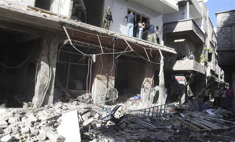 People gather around wreckage after a car bomb exploded in the Tadamon district of southern Damascus, in this handout photograph released by People gather around wreckage after a car bomb exploded in the Tadamon district of southern Damascus, in this handout photograph released by