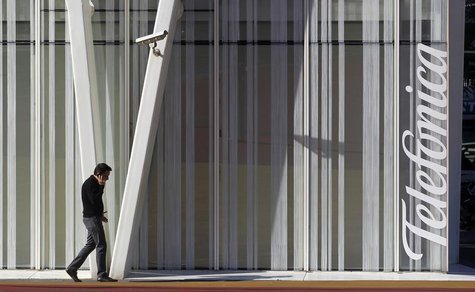 A man speaks by a mobile next to Telefonica's tower in Barcelona January 30, 2013. REUTERS/Albert Gea A man speaks by a mobile next to Telefonica's tower in Barcelona January 30, 2013. REUTERS/Albert Gea