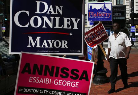 A pedestrian walks by campaign signs outside a polling station in Boston, Massachusetts September 24, 2013. REUTERS/Brian Snyder A pedestrian walks by campaign signs outside a polling station in Boston, Massachusetts September 24, 2013. REUTERS/Brian Snyder