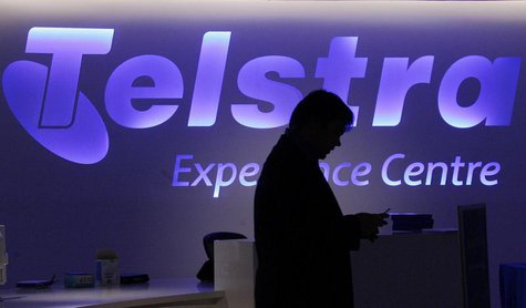 A man uses his mobile phone in front of a Telstra logo in central Sydney August 13, 2009. REUTERS/Daniel Munoz A man uses his mobile phone in front of a Telstra logo in central Sydney August 13, 2009. REUTERS/Daniel Munoz