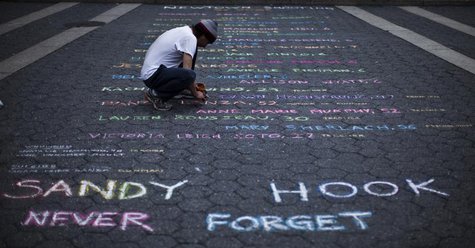 Street artist Mark Panzarino, 41, prepares a memorial as he writes the names of the Sandy Hook Elementary School victims during the six-mont Street artist Mark Panzarino, 41, prepares a memorial as he writes the names of the Sandy Hook Elementary School victims during the six-mont