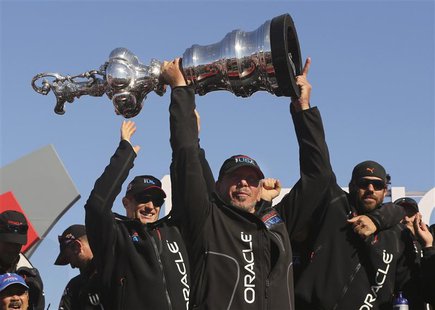 Oracle CEO Larry Ellison lifts the America's Cup with members of the Oracle Team USA after winning the overall title of the 34th America's C Oracle CEO Larry Ellison lifts the America's Cup with members of the Oracle Team USA after winning the overall title of the 34th America's C