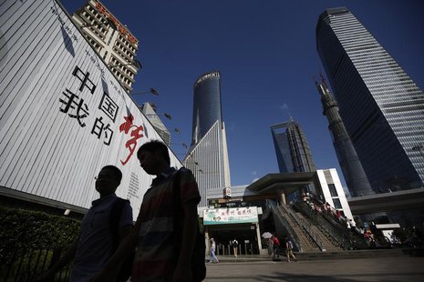 People walk past a billboard at the financial district of Pudong in Shanghai September 2, 2013. REUTERS/Aly Song People walk past a billboard at the financial district of Pudong in Shanghai September 2, 2013. REUTERS/Aly Song
