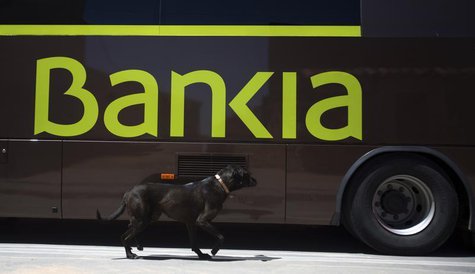 A dog walks past a bank bus during its monthly call on customers in the village of Corral de Ayllon, central Spain, June 4, 2013. REUTERS/Se A dog walks past a bank bus during its monthly call on customers in the village of Corral de Ayllon, central Spain, June 4, 2013. REUTERS/Se