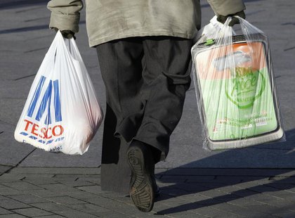 A woman carries shopping bags from Tesco and Asda in Long Eaton, central England January 12, 2012. REUTERS/Darren Staples A woman carries shopping bags from Tesco and Asda in Long Eaton, central England January 12, 2012. REUTERS/Darren Staples