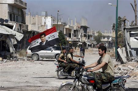 Forces loyal to Syria's President Bashar al-Assad carry the national flag as they ride on motorcycles in Qusair, after the Syrian army took control from rebel fighters, in this file picture taken June 5, 2013.
REUTERS/Mohamed Azakir/Files Forces loyal to Syria's President Bashar al-Assad carry the national flag as they ride on motorcycles in Qusair, after the Syrian army took control from rebel fighters, in this file picture taken June 5, 2013.
REUTERS/Mohamed Azakir/Files