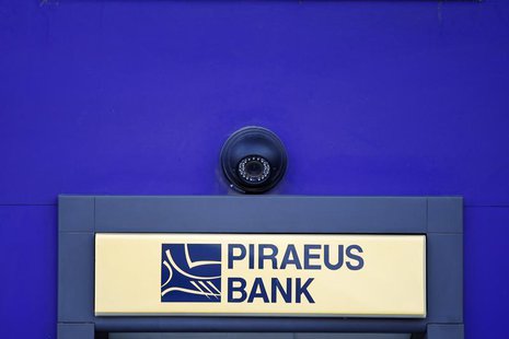 A surveillance camera is seen over the logo of Piraeus Bank on an ATM machine outside one of its branches in Bucharest April 18, 2013. REUTE A surveillance camera is seen over the logo of Piraeus Bank on an ATM machine outside one of its branches in Bucharest April 18, 2013. REUTE