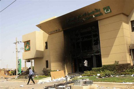 A man passes a burnt bank during protests over fuel subsidy cuts in Khartoum September 26, 2013. REUTERS/ Stringer A man passes a burnt bank during protests over fuel subsidy cuts in Khartoum September 26, 2013. REUTERS/ Stringer
