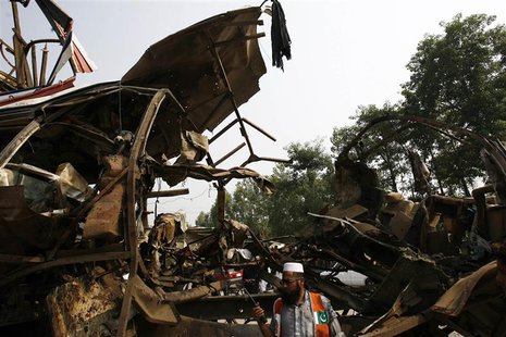 A rescue worker stands near the damaged bus after it was hit by a bomb attack on the outskirts of Peshawar September 27, 2013. REUTERS Khura A rescue worker stands near the damaged bus after it was hit by a bomb attack on the outskirts of Peshawar September 27, 2013. REUTERS Khura