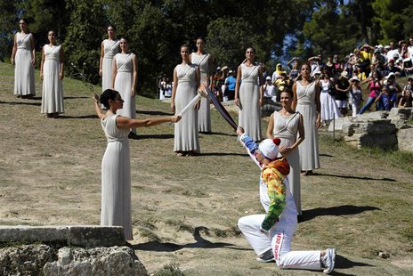 Greek actress Ino Menegaki, playing the role of High Priestess, passes the Olympic flame to Greek skier Yannis Antoniou, the first torchbear Greek actress Ino Menegaki, playing the role of High Priestess, passes the Olympic flame to Greek skier Yannis Antoniou, the first torchbear