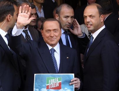 Silvio Berlusconi waves to supporters next to People of Freedom (PDL) Secretary Angelino Alfano (R) while showing the logo of his re-launche Silvio Berlusconi waves to supporters next to People of Freedom (PDL) Secretary Angelino Alfano (R) while showing the logo of his re-launche