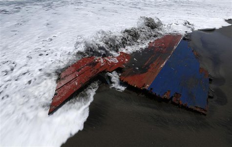 Waves wash over a piece of wreckage of a boat which sank, on Agrabinta beach on the outskirts of Sukabumi, Indonesia's West Java province Se Waves wash over a piece of wreckage of a boat which sank, on Agrabinta beach on the outskirts of Sukabumi, Indonesia's West Java province Se