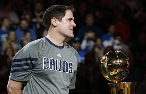 Dallas Mavericks owner Mark Cuban holds the Larry O'Brien Championship trophy during a ceremony before their NBA basketball game with the Mi Dallas Mavericks owner Mark Cuban holds the Larry O'Brien Championship trophy during a ceremony before their NBA basketball game with the Mi