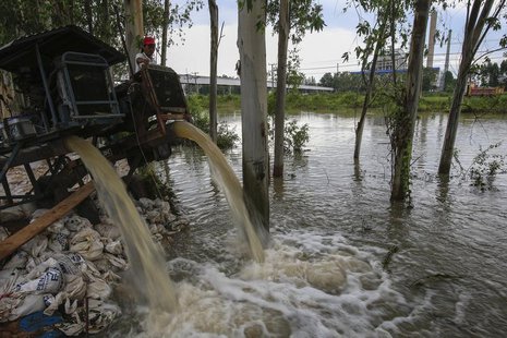 A man looks on as water is pumped out of a canal near 304 Industrial Estate at Srimahaphot district in Prachin Buri September 29, 2013. REUT A man looks on as water is pumped out of a canal near 304 Industrial Estate at Srimahaphot district in Prachin Buri September 29, 2013. REUT