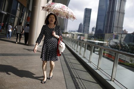 A woman walks with her pet dog at Lujiazui financial district of Pudong in Shanghai September 30, 2013. REUTERS/Aly Song A woman walks with her pet dog at Lujiazui financial district of Pudong in Shanghai September 30, 2013. REUTERS/Aly Song