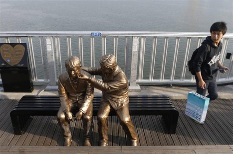 A man walks past a statue of a person comforting another on the Mapo Bridge, one of 25 bridges over the Han River, in central Seoul Septembe A man walks past a statue of a person comforting another on the Mapo Bridge, one of 25 bridges over the Han River, in central Seoul Septembe