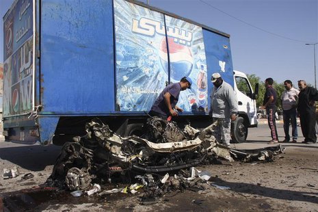 Residents inspect the mangled remains of a vehicle at the site of a car bomb attack in Baghdad's Sadr City, September 30, 2013. REUTERS/Wiss Residents inspect the mangled remains of a vehicle at the site of a car bomb attack in Baghdad's Sadr City, September 30, 2013. REUTERS/Wiss