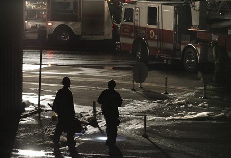 Firefighters carry equipment through foam sprayed on a fire that erupted after a twin-jet Cessna Citation crashed into a hangar after landin Firefighters carry equipment through foam sprayed on a fire that erupted after a twin-jet Cessna Citation crashed into a hangar after landin