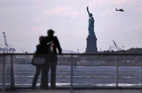 Tourists pause to view the Statue of Liberty from a Liberty Island ferry boat at Battery Park in New York, September 30, 2013. REUTERS/Mike Tourists pause to view the Statue of Liberty from a Liberty Island ferry boat at Battery Park in New York, September 30, 2013. REUTERS/Mike