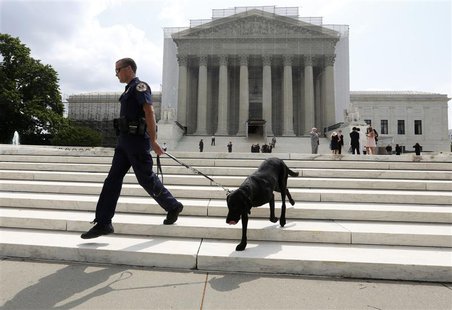 A policeman and his bomb sniffing dog walk in front of the Supreme Court in Washington, April 17, 2013. REUTERS/Larry Downing A policeman and his bomb sniffing dog walk in front of the Supreme Court in Washington, April 17, 2013. REUTERS/Larry Downing