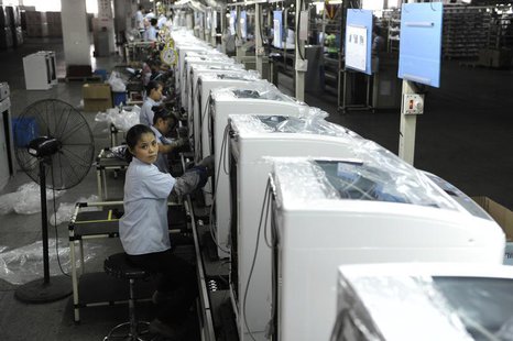 Employees assemble washing machines on the production line inside a factory of Hefei Rongshida Sanyo Electric in Hefei, Anhui province Augus Employees assemble washing machines on the production line inside a factory of Hefei Rongshida Sanyo Electric in Hefei, Anhui province Augus