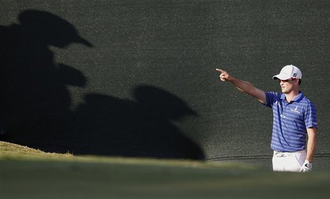 Zach Johnson of U.S. points towards where he is intending to hit his ball from the bunker where fans are standing on the 18th green, during Zach Johnson of U.S. points towards where he is intending to hit his ball from the bunker where fans are standing on the 18th green, during