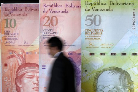 A man walks past big samples of Venezuelan bank notes at the Central Bank headquarters in Caracas August 22, 2013. REUTERS/Carlos Garcia Raw A man walks past big samples of Venezuelan bank notes at the Central Bank headquarters in Caracas August 22, 2013. REUTERS/Carlos Garcia Raw