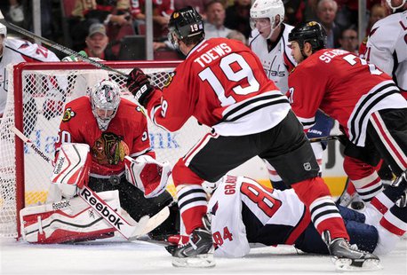 Oct 1, 2013; Chicago, IL, USA; Chicago Blackhawks goalie Corey Crawford (50) makes a save in front of center Jonathan Toews (19) and Washing Oct 1, 2013; Chicago, IL, USA; Chicago Blackhawks goalie Corey Crawford (50) makes a save in front of center Jonathan Toews (19) and Washing
