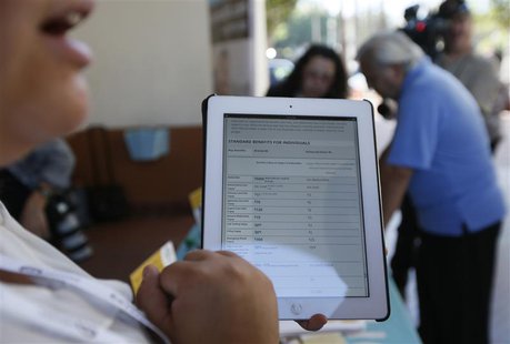 A woman explains healthcare benefits at a Covered California event which marks the opening of the state's Affordable Healthcare Act, commonl A woman explains healthcare benefits at a Covered California event which marks the opening of the state's Affordable Healthcare Act, commonl