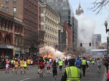 Runners continue to run towards the finish line of the Boston Marathon as an explosion erupts near the finish line of the race in this photo Runners continue to run towards the finish line of the Boston Marathon as an explosion erupts near the finish line of the race in this photo
