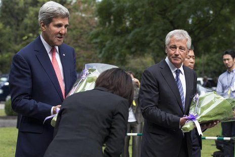 A woman bows to U.S. Secretary of State John Kerry (L) and U.S. Secretary of Defense Chuck Hagel as they participate in a wreath- laying cer A woman bows to U.S. Secretary of State John Kerry (L) and U.S. Secretary of Defense Chuck Hagel as they participate in a wreath- laying cer
