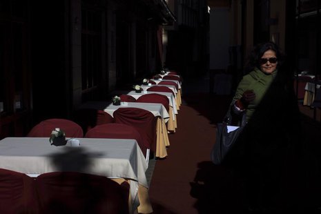 A woman walks past an empty restaurant in the Andalusian capital of Seville January 23, 2013. REUTERS/Marcelo del Pozo A woman walks past an empty restaurant in the Andalusian capital of Seville January 23, 2013. REUTERS/Marcelo del Pozo
