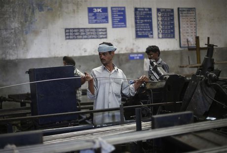 An employee holds a steel rod as he works on the production line inside Hallmark steel factory in Bhiwadi in the desert Indian state of Raja An employee holds a steel rod as he works on the production line inside Hallmark steel factory in Bhiwadi in the desert Indian state of Raja