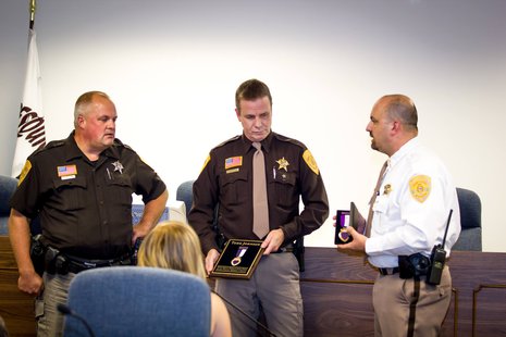 Deputy Todd Johnson awarded a purple heart by Sheriff Sam Wollin and Chief Deputy Terry Fahrenkrug. Photo: Adams Co. Sheriff's Department Deputy Todd Johnson awarded a purple heart by Sheriff Sam Wollin and Chief Deputy Terry Fahrenkrug. Photo: Adams Co. Sheriff's Department