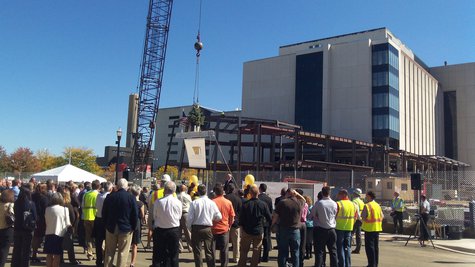 Crowd gathers to sign the beam and then sent it up to its position in the frame. Crowd gathers to sign the beam and then sent it up to its position in the frame.