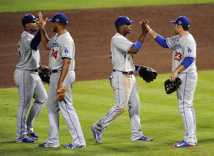 Oct 3, 2013; Atlanta, GA, USA; Los Angeles Dodgers first baseman Adrian Gonzalez (23) and right fielder Yasiel Puig (center) celebrate after Oct 3, 2013; Atlanta, GA, USA; Los Angeles Dodgers first baseman Adrian Gonzalez (23) and right fielder Yasiel Puig (center) celebrate after