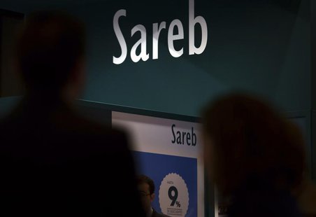 People walks past the stand of Spain's bad bank Sareb during a real estate fair in Madrid May 30, 2013. REUTERS/Sergio Perez People walks past the stand of Spain's bad bank Sareb during a real estate fair in Madrid May 30, 2013. REUTERS/Sergio Perez