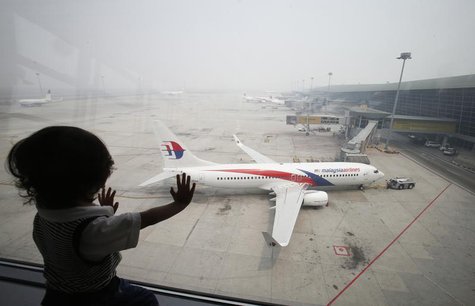 A boy looks out a window overlooking the haze-covered Kuala Lumpur International Airport in Sepang, outside Kuala Lumpur June 24, 2013. REUT A boy looks out a window overlooking the haze-covered Kuala Lumpur International Airport in Sepang, outside Kuala Lumpur June 24, 2013. REUT
