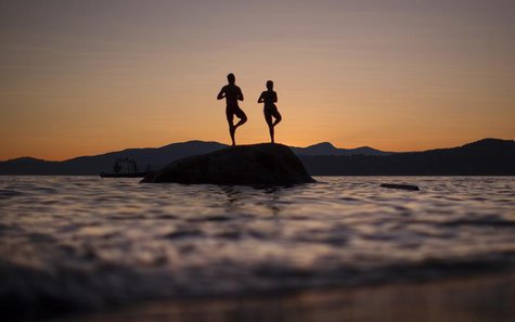 A couple stand on a rock facing the sunset along the shores of English Bay in Vancouver, British Columbia July 23, 2013. REUTERS/Andy Clark A couple stand on a rock facing the sunset along the shores of English Bay in Vancouver, British Columbia July 23, 2013. REUTERS/Andy Clark