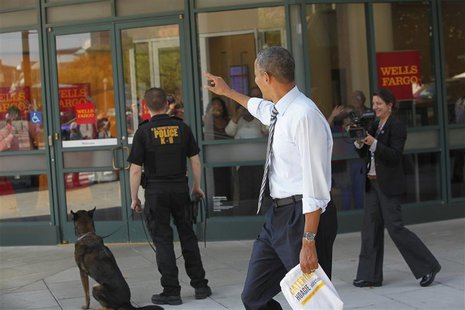 U.S. President Barack Obama waves at people in a bank vestibule after he and Vice President Joe Biden (not pictured) bought lunch at a sandw U.S. President Barack Obama waves at people in a bank vestibule after he and Vice President Joe Biden (not pictured) bought lunch at a sandw