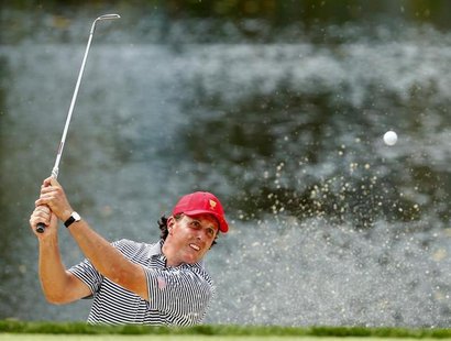 U.S. golfer Phil Mickelson hits from a sand trap on the third hole as he and teammate Keegan Bradley play against the International team of U.S. golfer Phil Mickelson hits from a sand trap on the third hole as he and teammate Keegan Bradley play against the International team of