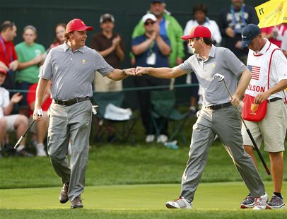 U.S. teammates Phil Mickelson (L) and Keegan Bradley bump fists after winning the 11th hole against International teammates Jason Day of Aus U.S. teammates Phil Mickelson (L) and Keegan Bradley bump fists after winning the 11th hole against International teammates Jason Day of Aus