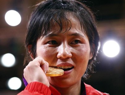 North Korea's An Kum Ae bites her gold medal as she celebrates during the awards ceremony for the women's -52kg judo competition at the Lond North Korea's An Kum Ae bites her gold medal as she celebrates during the awards ceremony for the women's -52kg judo competition at the Lond