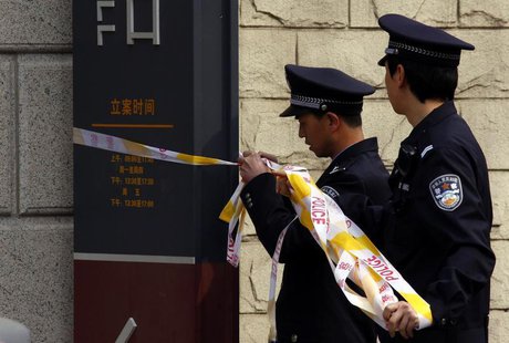 Policemen remove tape from the entrance to the courthouse where disabled lawyer Ni Yulan, and her husband Dong Jiqin were being sentenced, i Policemen remove tape from the entrance to the courthouse where disabled lawyer Ni Yulan, and her husband Dong Jiqin were being sentenced, i